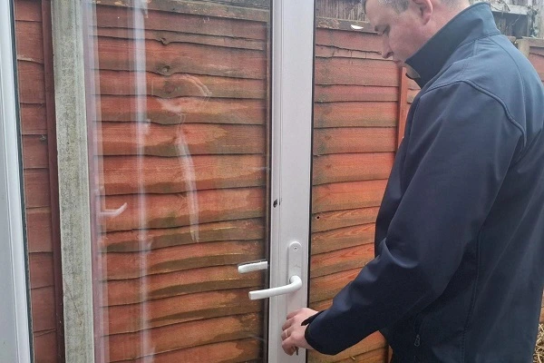 Locksmith removing an existing door lock as part of a professional lock change