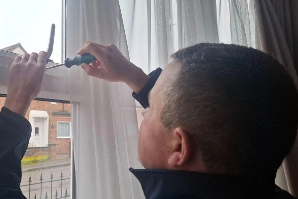 Locksmith removing a faulty uPVC window handle as part of a professional uPVC window repair.